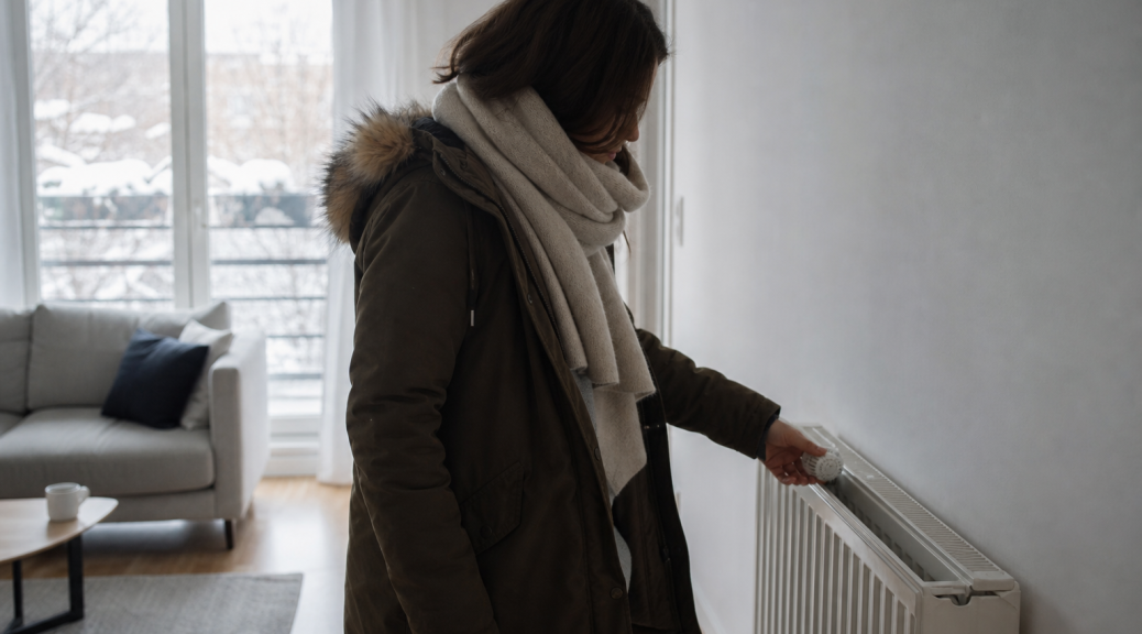 Personne emmitouflée vérifiant un radiateur intérieur